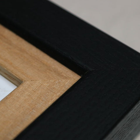 The three frame corners mitred together: black, oak and white